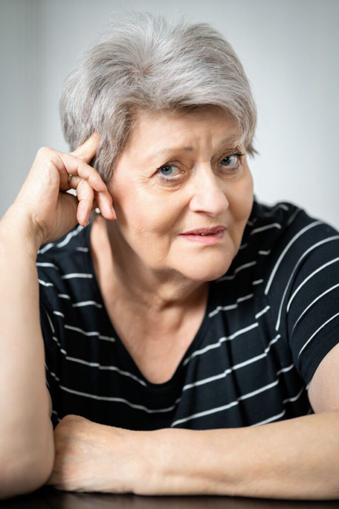 Porträtaufnahme von Gabriele Walter. Sie blickt freundlich in die Kamera, stützt ihren Kopf leicht auf die rechte Hand und trägt ein schwarz-weiß gestreiftes Shirt vor einem hellen, neutralen Hintergrund.